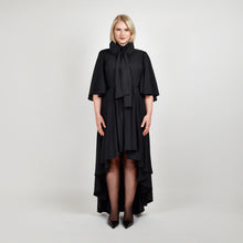 Load image into Gallery viewer, Front view of the Femponiq Bow Tie Neck Cape Sleeve Maxi Dress in Black showcasing its elegant bow tie neckline, flowing cape sleeves, and floor-length silhouette.