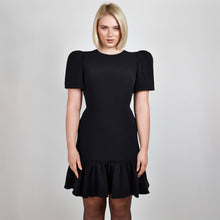 Load and play video in Gallery viewer, Video clip of model walking in Femponiq Black Pleated Shoulder Peplum Hem Cady Dress, showcasing its fluid movement and sophisticated design.