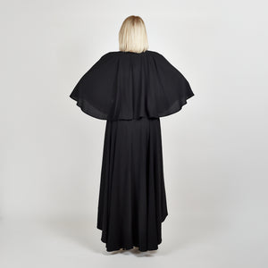 Back view of the Femponiq Bow Tie Neck Cape Sleeve Maxi Dress in Black showcasing its elegant bow tie neckline, flowing cape sleeves, and floor-length silhouette.
