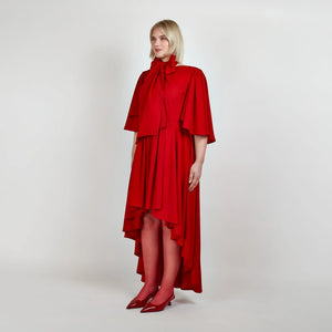 Side view of the Femponiq Bow Tie Neck Cape Sleeve Maxi Dress in Deep Red, showcasing its elegant bow tie neckline, flowing cape sleeves, and floor-length silhouette.