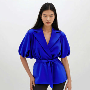 Model wearing a blue belted puff sleeve sateen top with puffed sleeves on a white background