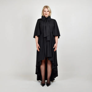 Front view of the Femponiq Bow Tie Neck Cape Sleeve Maxi Dress in Black showcasing its elegant bow tie neckline, flowing cape sleeves, and floor-length silhouette.