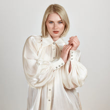 Load image into Gallery viewer, Model wearing the Femponiq Gathered Neck Voluminous Raglan Sleeve Shirt in Pearl White, highlighting the gathered neckline and luxurious fabric texture in a close-up view.
