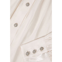 Load image into Gallery viewer, Close-up of the button and cuff detail on the front view of the Femponiq Gathered Neck Voluminous Raglan Sleeve Shirt in Pearl White, featuring elegant craftsmanship and unique design accents.
