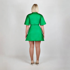 Back view of model in Femponiq Green Pleated Shoulder Kimono Sleeve Satin Duchess Dress, emphasizing the smooth satin finish and  flared structured skirt and sleeves.