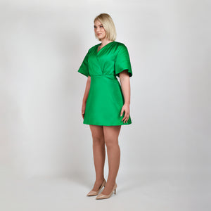 Side view of model in Femponiq Green Pleated Shoulder Kimono Sleeve Satin Duchess Dress, highlighting the graceful pleated shoulders and the flattering flared 
silhouette.