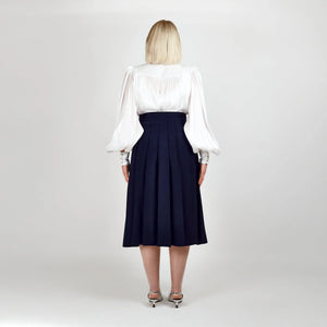 Back view of the Femponiq High-Waisted Pleated Midi Skirt with Asymmetric Dual Side Slits in Navy, featuring an elegant pleated design and asymmetric silhouette.
