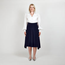 Load image into Gallery viewer, Front view of the Femponiq High-Waisted Pleated Midi Skirt with Asymmetric Dual Side Slits in Navy, featuring an elegant pleated design and asymmetric silhouette.


