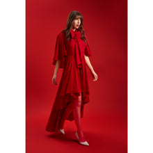 Load image into Gallery viewer, Model wearing the Femponiq Red Bow Tie Neck Cape Maxi Dress, highlighting the elegant bow neckline, flowing cape sleeves and high–low layered hem in a bold all-red setting.
