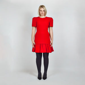 Model wearing the Femponiq Red Pleated Shoulder Peplum Hem Cady Dress, highlighting the sophisticated pleated shoulder detail and the flattering, feminine peplum hem. The dress enhances an hourglass figure with its sculpted silhouette, offering a timeless and elegant design.