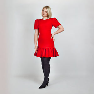 Another side view of model in Femponiq Red Pleated Shoulder Peplum Hem Cady Dress, highlighting the dress’s sleek silhouette, pleated shoulder sleeves and feminine peplum accent. 