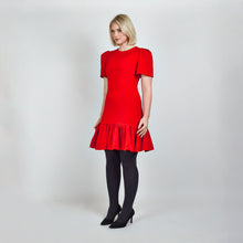 Load image into Gallery viewer, Side view of model in Femponiq Red Pleated Shoulder Peplum Hem Cady Dress, highlighting the dress’s sleek silhouette, pleated shoulder sleeves and feminine peplum accent. 
