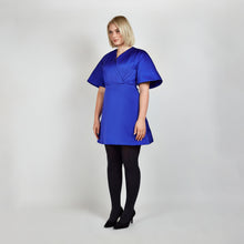 Load image into Gallery viewer, Side view of model in Femponiq Royal Blue Pleated Shoulder Kimono Sleeve Satin Duchess Dress, highlighting the graceful pleated shoulders and the flattering flared 
silhouette.
