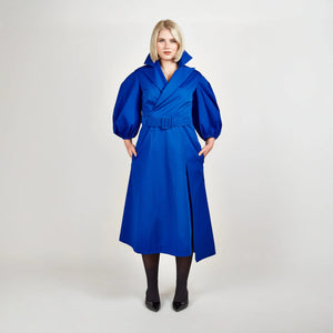 Front view of Femponiq’s Wide Lapel Asymmetric Belted Midi Cotton Dress in a vibrant blue hue, showcasing the stylish wide lapels, asymmetrical hemline, side slit pockets and flattering belt that accentuates the waist.