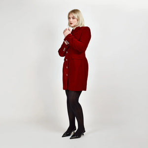 Model wearing the Femponiq Velvet Tailored Blazer Dress in Red, showcasing a side view that highlights the hourglass silhouette and elegant design, with sleeves adorned with sparkling buttons.