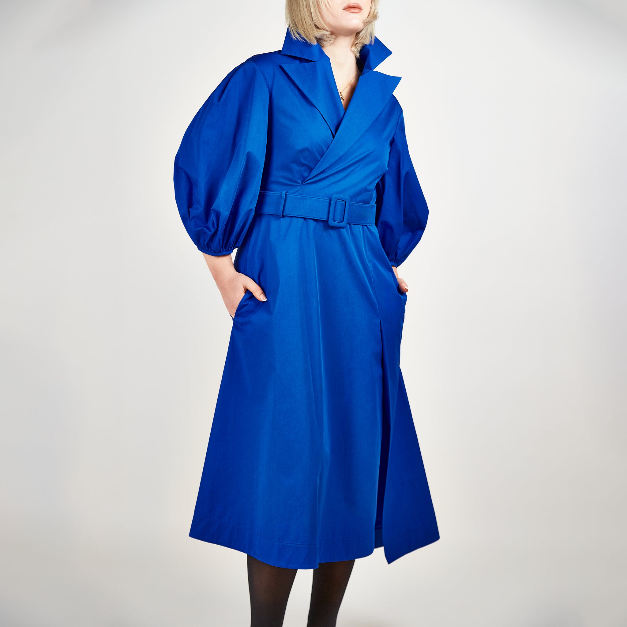 Video of a model showcasing the Femponiq Wide Lapel Asymmetric Belted Midi Cotton Dress in Blue, featuring its tailored silhouette, wide lapel design, and elegant belted waist.