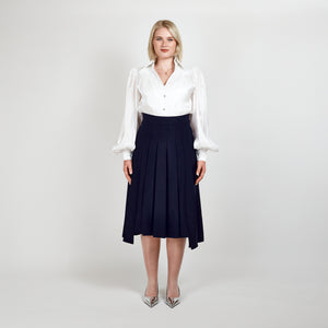 Video of a model wearing the Femponiq High-Waisted Navy Pleated Midi Skirt with Asymmetric Slits and Sheer White Puff Sleeve V-Neck Gathered Shirt, showcasing elegance and movement.