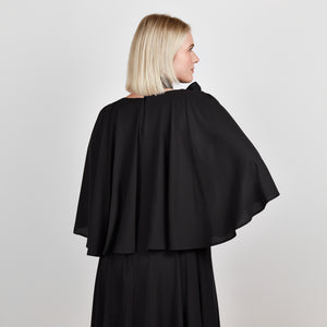 Video of a model wearing the Femponiq Bow Tie Neck Cape Sleeve Maxi Dress in Black, highlighting its flowing silhouette and elegant bow tie neckline.